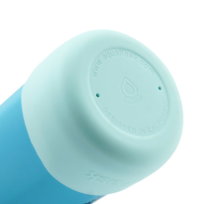 Botella de agua de acero inoxidable con aislamiento de la colección Colorwave de AquaFlask en color Club Azure, con acabado degradado suave, tapa de rosca con asa de transporte y base de silicona, fotografiada sobre fondo blanco