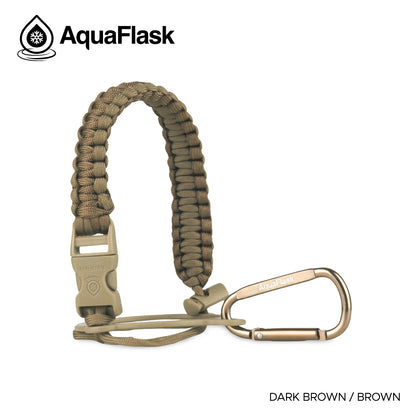 Accesorio de asa de paracord Aquaflask presentado sobre un fondo blanco con el logotipo de Aquaflask. El accesorio está fabricado con paracord firmemente tejido que forma un asa corta. Incluye una hebilla plástica de liberación lateral, un lazo ajustable que se coloca alrededor del cuello de la botella y un mosquetón metálico negro para su sujeción. El producto está etiquetado como compatible con botellas Aquaflask de 14 oz, 18 oz, 22 oz, 32 oz, 40 oz y 64 oz.