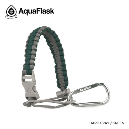 Accesorio de asa de paracord Aquaflask presentado sobre un fondo blanco con el logotipo de Aquaflask. El accesorio está fabricado con paracord firmemente tejido que forma un asa corta. Incluye una hebilla plástica de liberación lateral, un lazo ajustable que se coloca alrededor del cuello de la botella y un mosquetón metálico negro para su sujeción. El producto está etiquetado como compatible con botellas Aquaflask de 14 oz, 18 oz, 22 oz, 32 oz, 40 oz y 64 oz.