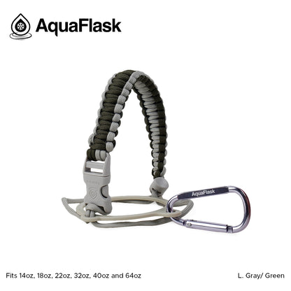 Accesorio de asa de paracord Aquaflask presentado sobre un fondo blanco con el logotipo de Aquaflask. El accesorio está fabricado con paracord firmemente tejido que forma un asa corta. Incluye una hebilla plástica de liberación lateral, un lazo ajustable que se coloca alrededor del cuello de la botella y un mosquetón metálico negro para su sujeción. El producto está etiquetado como compatible con botellas Aquaflask de 14 oz, 18 oz, 22 oz, 32 oz, 40 oz y 64 oz.