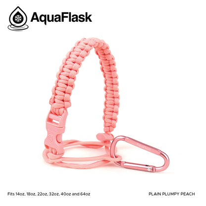 Accesorio de asa de paracord Aquaflask presentado sobre un fondo blanco con el logotipo de Aquaflask. El accesorio está fabricado con paracord firmemente tejido que forma un asa corta. Incluye una hebilla plástica de liberación lateral, un lazo ajustable que se coloca alrededor del cuello de la botella y un mosquetón metálico negro para su sujeción. El producto está etiquetado como compatible con botellas Aquaflask de 14 oz, 18 oz, 22 oz, 32 oz, 40 oz y 64 oz.