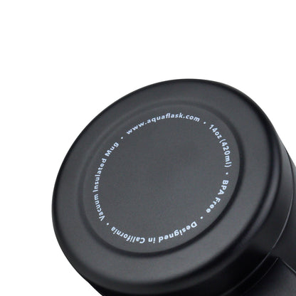 Taza térmica AquaFlask en color Jet Black con acabado negro mate suave, borde de acero inoxidable, asa ergonómica y tapa antiderrames, fotografiada sobre fondo blanco